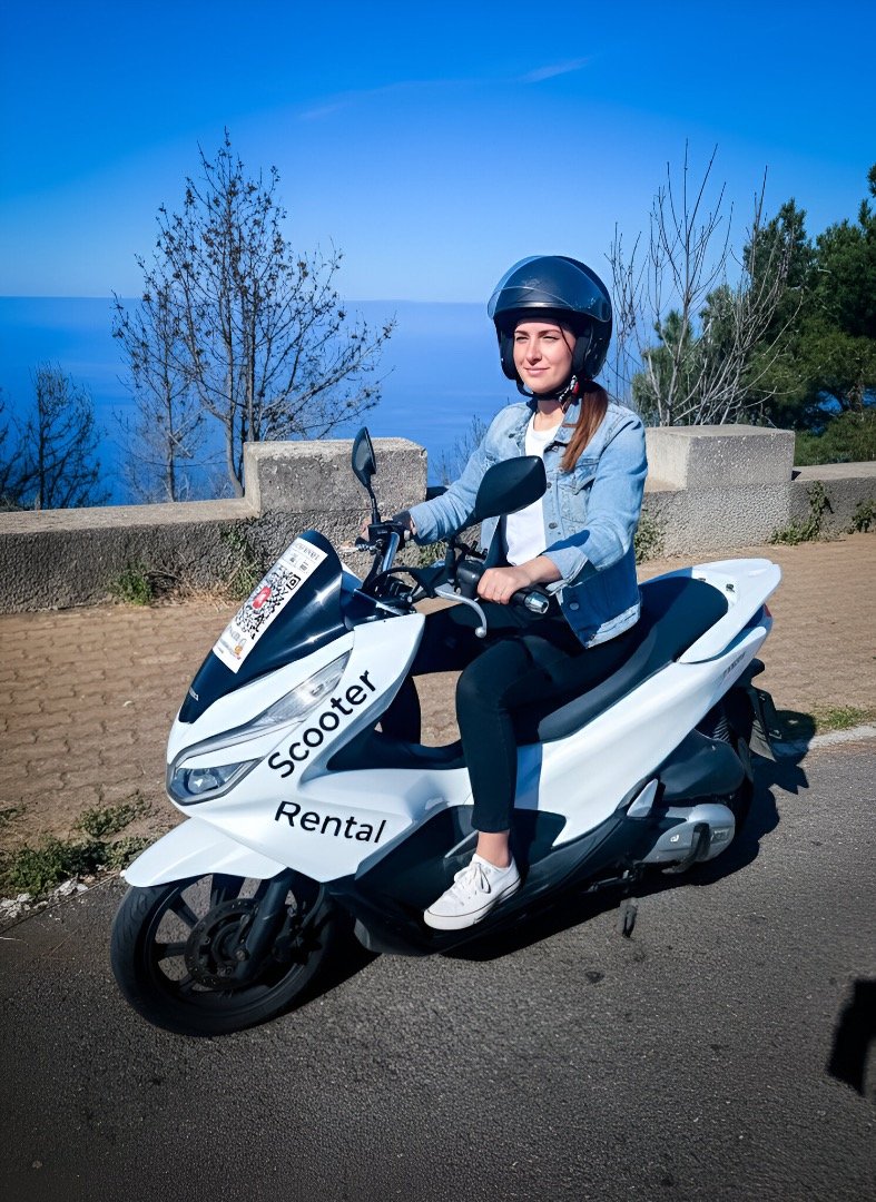Rider on a white scooter overlooking the ocean in Madeira