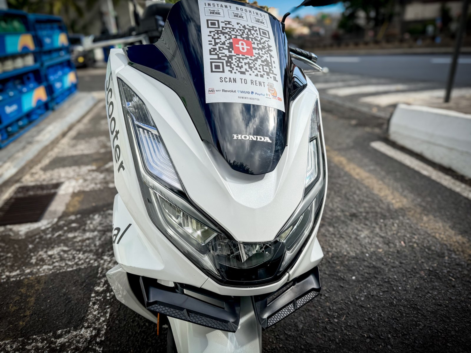 Front view of a white Honda rental scooter with a booking QR code